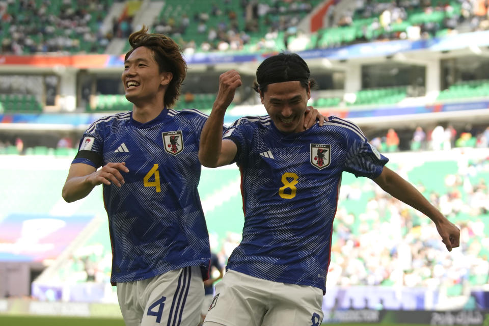 Japan's Takumi Minamino, right, celebrates after scoring the opening goal during the Asian Cup Group D soccer match between Japan and Vietnam at Al Thumama Stadium in Doha, Qatar, Sunday, Jan. 14, 2024. (AP Photo/Thanassis Stavrakis)