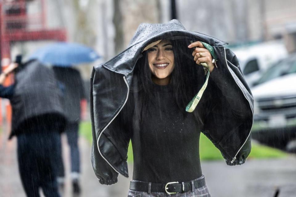 Azaria Loya, of Sacramento, covers herself from the rain on Friday, March 1, 2024, on 22nd Street in midtown Sacramento. More rain is forecast for Friday, April 12.