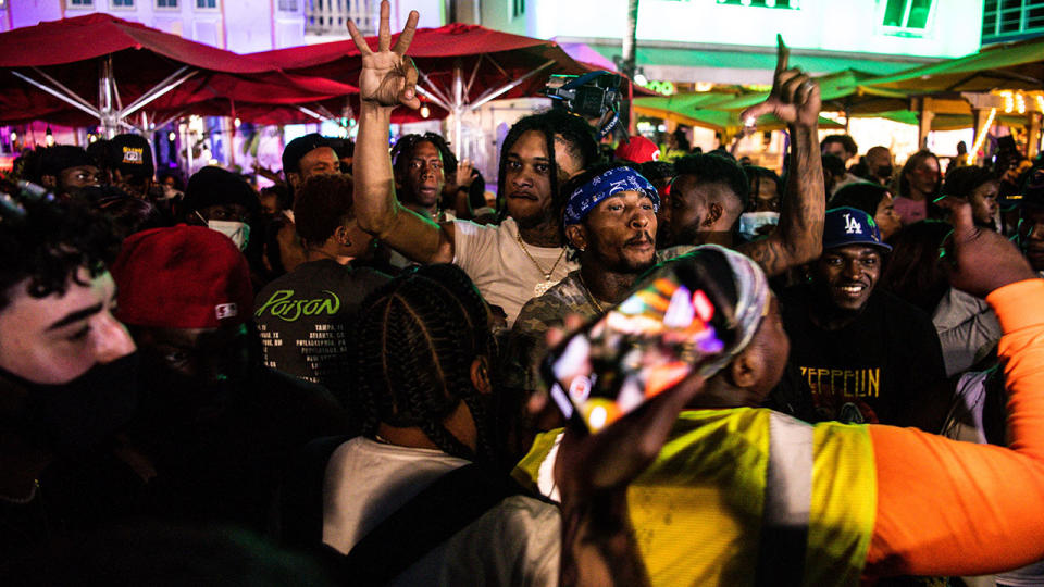 Revellers, pictured here dancing on Ocean Drive in Miami Beach. 