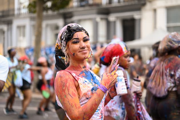 A woman covered in paint and colorful powder participates in Dutty Mas, which takes place on the second day of Notting Hill Carnival and signifies the start of the Carnival parade. (Photo: Clara Watt for HuffPost)