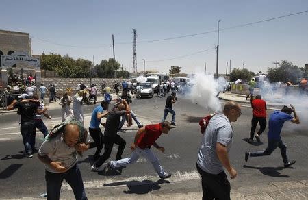 Palestinian protesters run away from tear gas fired by Israeli soldiers during clashes after Friday prayers in the Arab east Jerusalem neighbourhood of Ras al-Amud July 4, 2014. REUTERS/Ammar Awad/Files