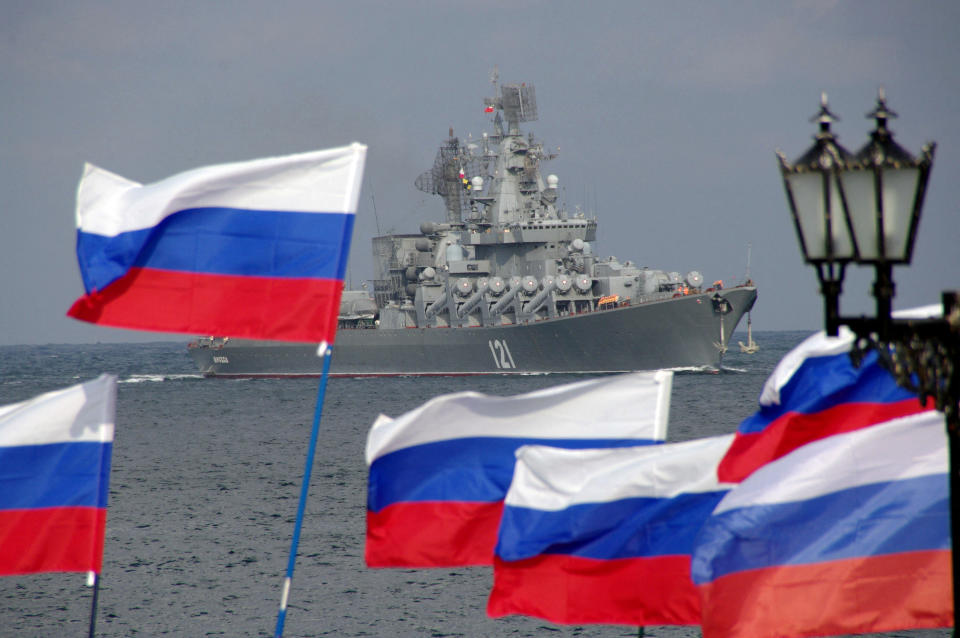 Russian supporters wave flags as they welcome missile cruiser Moskva.