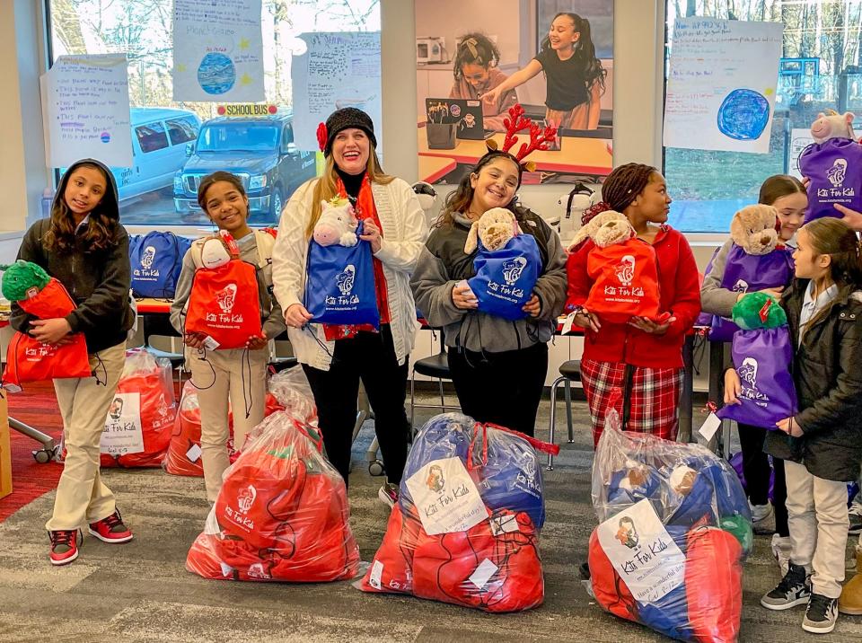 Heather Johnston of Kits for Kids poses with the girls and their gift bags.