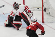 Switzerland's Alina Muller (25) scores a goal against Canada goalkeeper Ann-Renee Desbiens (35) during a women's semifinal hockey game at the 2022 Winter Olympics, Monday, Feb. 14, 2022, in Beijing. (AP Photo/Petr David Josek)