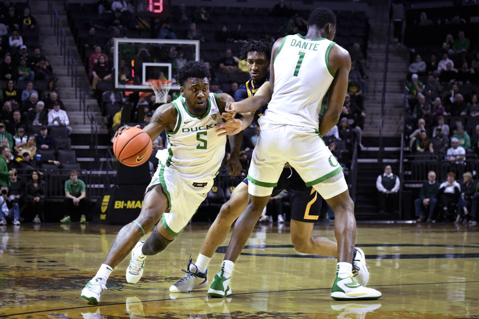 Oregon guard Jermaine Couisnard (5) moves around a screen by center N'Faly Dante (1) on California forward Grant Newell (14) during the first half of an NCAA college basketball game Thursday, March 2, 2023, in Eugene, Ore. (AP Photo/Andy Nelson)