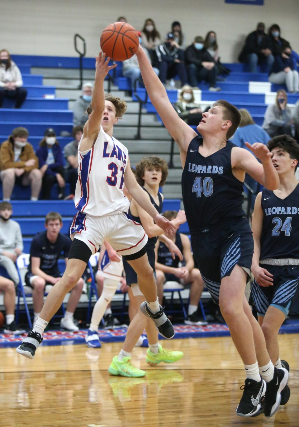 Chance Casenhiser (31) of Lake takes a shot while being guarded by AJ Lingenhoel (40) of Louisville during their game at Lake on Tuesday, Feb. 16, 2021.