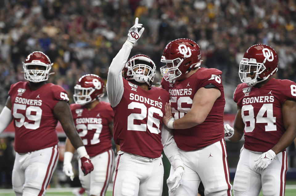 Oklahoma running back Kennedy Brooks (26) celebrates with offensive lineman Creed Humphrey (56) after rushing for a touchdown against Baylor during the first half of an NCAA college football game for the Big 12 Conference championship, Saturday, Dec. 7, 2019, in Arlington, Texas. (AP Photo/Jeffrey McWhorter)