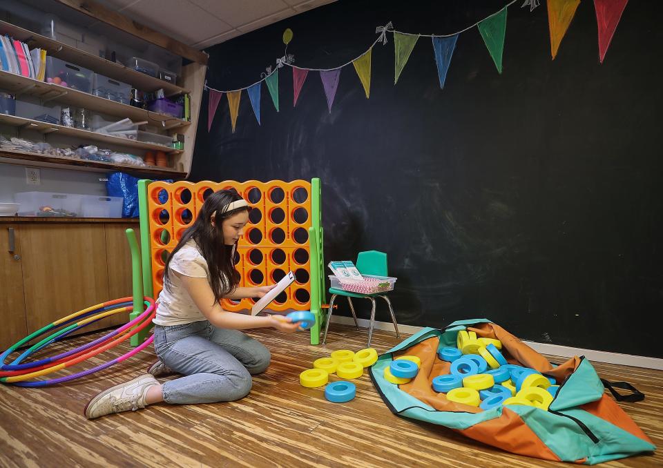Bainbridge Work Ready participant Hanah Deets takes inventory of a giant Connect Four game as she helps prepare for KiDiMu's upcoming Celebrate Bainbridge Island Kids Zone event on June 23.