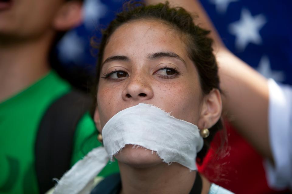 A demonstrator covers her mouth with a rag to prostest government censorship, during a march to Venezuelan Telecommunications Regulator Office or CONATEL in Caracas, Venezuela, Monday, Feb17, 2014. Students, who’ve spent the past week on the streets alternating between peaceful protests by day and battles with police at night, marched on Monday to Venezuela’s telecom regulator to demand it lift all restrictions on the media’s coverage of the unfolding political crisis. (AP Photo/Alejandro Cegarra)