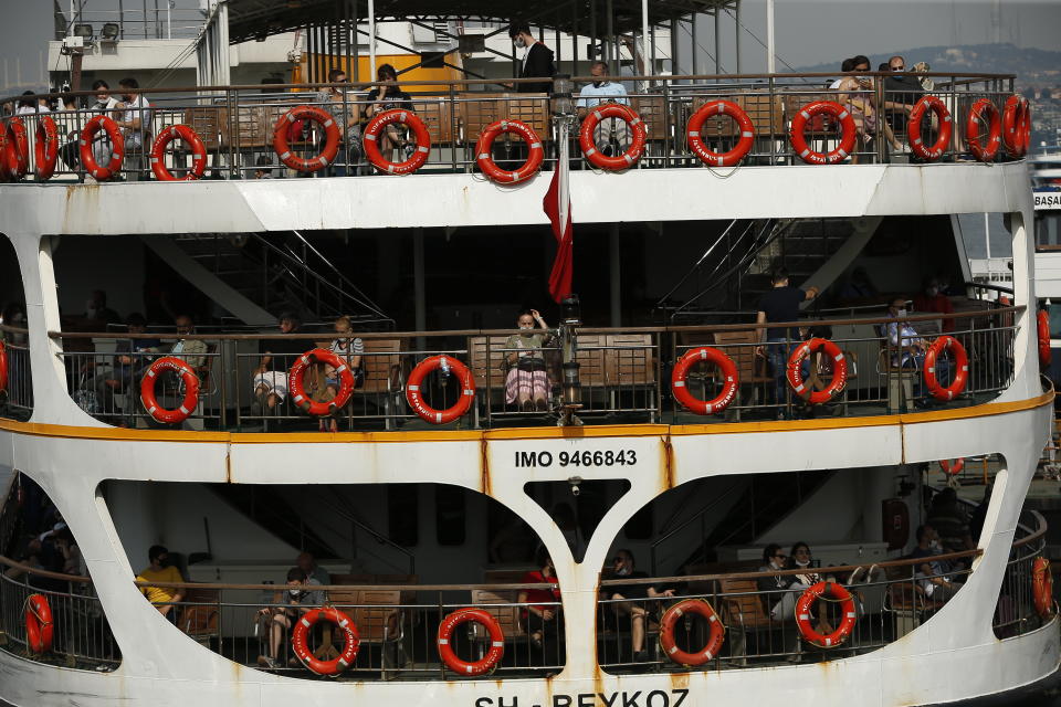 People, some wearing protective mask against the spread of coronavirus, travel on a boat in Bosphorus Strait connecting Europe and Asia in Istanbul, Thursday, June 18, 2020. Turkish authorities have made the wearing of masks mandatory in Istanbul, Ankara and Bursa to curb the spread of COVID-19 following an uptick in confirmed cases since the reopening of many businesses. (AP Photo/Emrah Gurel)