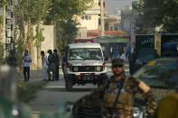 An ambulance is at hand as Afghan security personnel work near the site following a raid that targeted the elite American University of Afghanistan, in Kabul on August 25, 2016