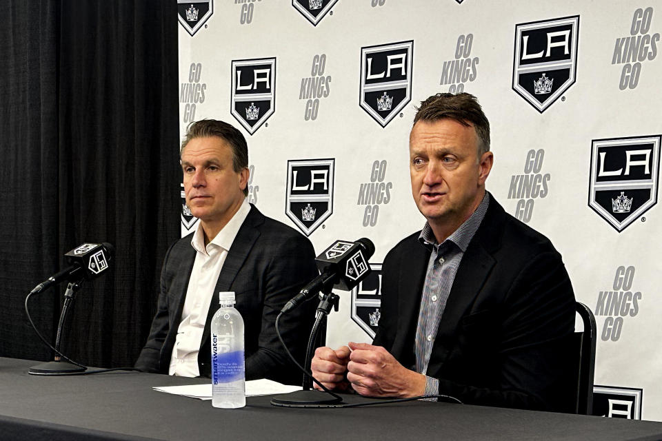 Los Angeles Kings head coach Jim Hiller, left, and general manager Rob Blake speak to reporters at the NHL hockey club's training complex in El Segundo, Calif., Thursday, May 23, 2024. Hiller has been named the Kings' permanent head coach after guiding them to a first-round playoff exit as the interim head coach this season. (AP Photo/Greg Beacham)