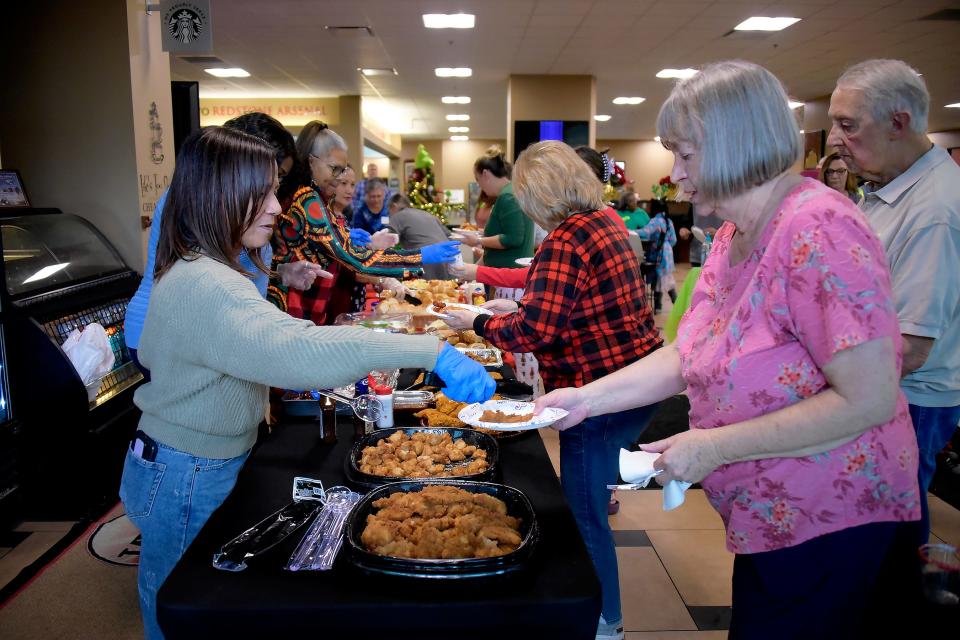 U.S. Army Space and Missile Defense Command volunteers serve lunch to family members of fallen service members during a USASMDC and Survivor Outreach Services Happy Who-liday Party at Java Café on Redstone Arsenal, Alabama, Dec. 2, 2023.