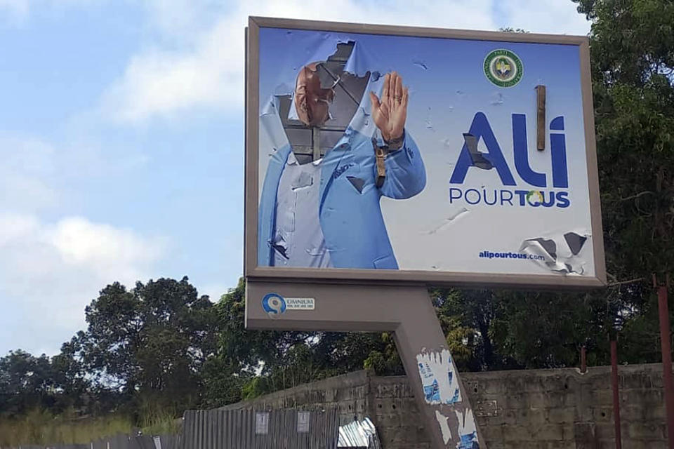 A defaced billboard of Gabon President Ali Bongo Ondimba is seen on an empty street in Libreville, Gabon, Wednesday Aug. 30, 2023. Mutinous soldiers speaking on state television announced that they had seized power in and were overturning the results of a presidential election that was to extend the Bongo family's 55-year hold on power. (AP Photo/Yves Laurent)