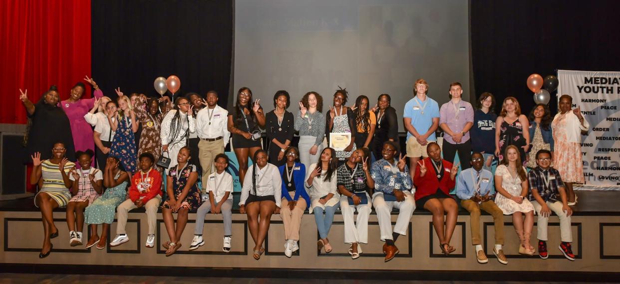 Members of the Mediation Center of the Coastal Empire pose at the end of the center's 2024 Youth Awards ceremony on April 17, 2024 on the stage at Herschel V. Jenkins High School.