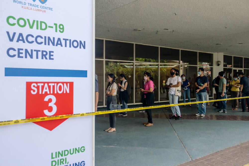 People queue outside the World Trade Centre Kuala Lumpur as they wait to receive the AstraZeneca Covid jab May 16, 2021. ― Picture by Firdaus Latif