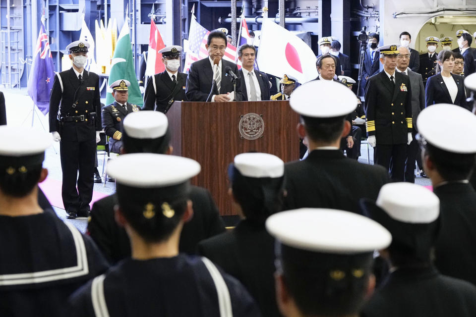 Japanese Prime Minister Fumio Kishida, center, delivers a speech on the Maritime Self Defense Force's helicopter carrier JS Izumo during an international fleet review in Sagami Bay, southwest of Tokyo, Sunday, Nov. 6, 2022. Kishida, at an international fleet review Sunday, said his country urgently needs to build up military capabilities as it faces worsening security environment in the East and South China Seas and threats from North Korea’s nuclear and missile advancement and Russia’s war on Ukraine.(Kyodo News via AP)