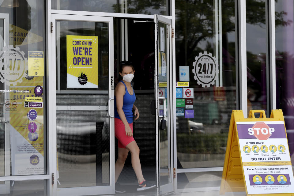 A person wears a mask while leaving a Planet Fitness gym location during the coronavirus pandemic, in Des Plaines, Ill., Wednesday, July 29, 2020. Planet Fitness will require masks at all locations beginning Aug. 1. Currently, all Planet Fitness employees are required to wear masks. (AP Photo/Nam Y. Huh)