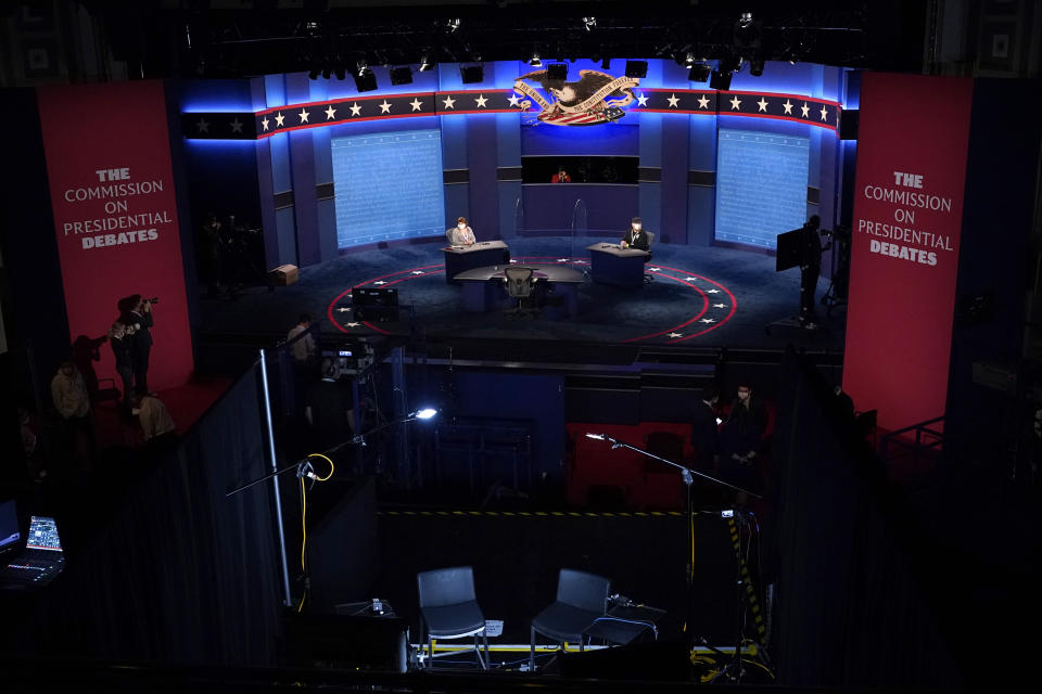 Members of the production crew stand in on the stage near plexiglass barriers which will serve as a way to protect the spread of COVID-19 as preparations take place for the vice presidential debate at the University of Utah, Tuesday, Oct. 6, 2020, in Salt Lake City. The vice presidential debate between Vice President Mike Pence and Democratic vice presidential candidate Sen. Kamala Harris, D-Calif., is scheduled for Oct. 7. (AP Photo/Julio Cortez)