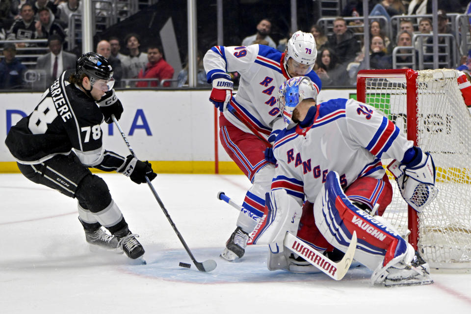 Los Angeles Kings right wing Alex Laferriere, left, has a shot blocked by New York Rangers goaltender Jonathan Quick (32), as defenseman K'Andre Miller assists during the second period of an NHL hockey game Saturday, Jan. 20, 2024, in Los Angeles. (AP Photo/Jayne-Kamin-Oncea)