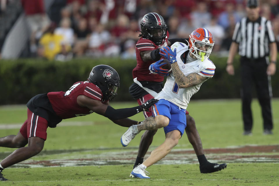 FILE - Florida wide receiver Ricky Pearsall (1) is tackled by South Carolina defensive back Jalon Kilgore (24) and defensive back O'Donnell Fortune (3) during the second half of an NCAA college football game on Saturday, Oct. 14, 2023, in Columbia, S.C. The former Florida standout is one of nearly a dozen receivers expected to be selected in the first two rounds of the draft beginning Thursday night. (AP Photo/Artie Walker Jr., File)