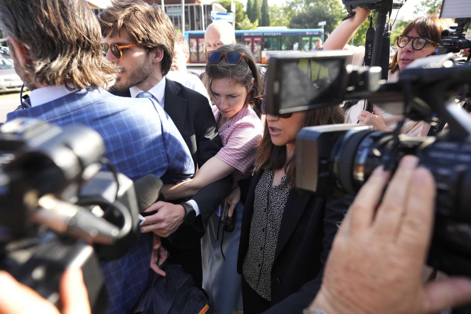 Amanda Knox arrives flanked by her husband Christopher Robinson, left, at the Florence courtroom in Florence, Italy, Wednesday, June 5, 2024. Amanda Knox returns to an Italian courtroom Wednesday for the first time in more than 12½ years to clear herself "once and for all" of a slander charge that stuck even after she was exonerated in the brutal 2007 murder of her British roommate in the idyllic hilltop town of Perugia. (AP Photo/Antonio Calanni)