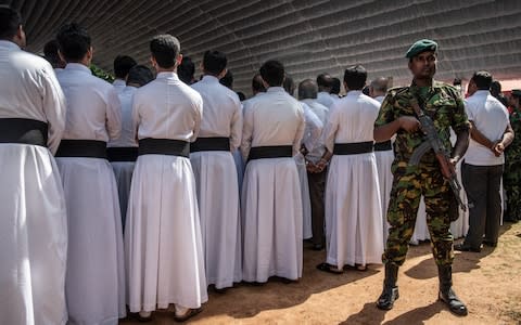 A soldier guards clergymen attending the mass funeral - Credit: Carl Court/&nbsp;Getty Images AsiaPac