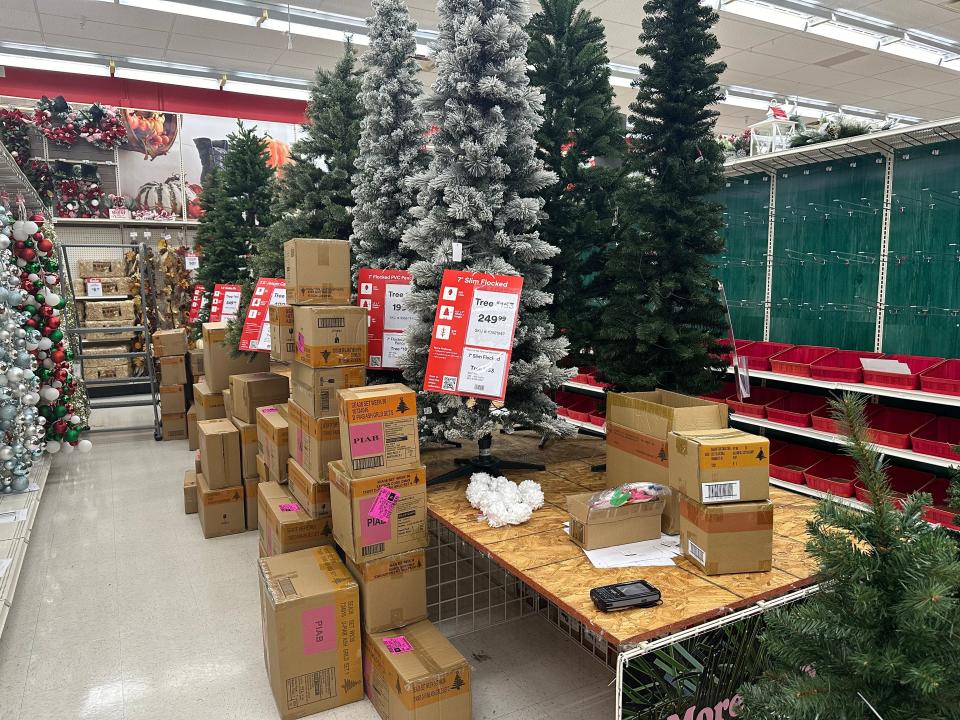 Christmas trees on display next to cardboard boxes in aisle of craft store