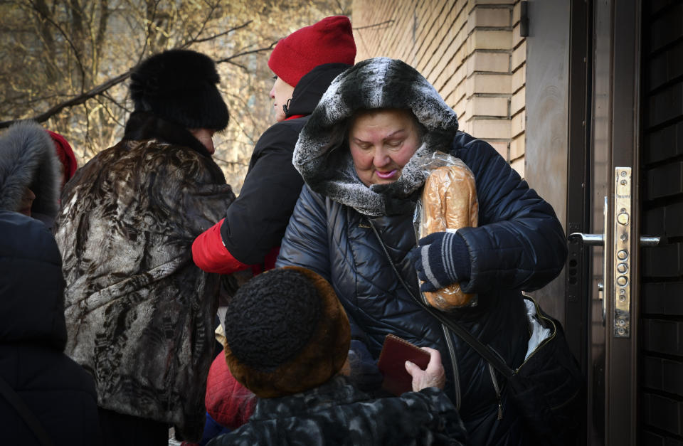 People receive bread at humanitarian aid distribution spot in Kramatorsk, Ukraine, Wednesday, Dec. 7, 2022. (AP Photo/Andriy Andriyenko)