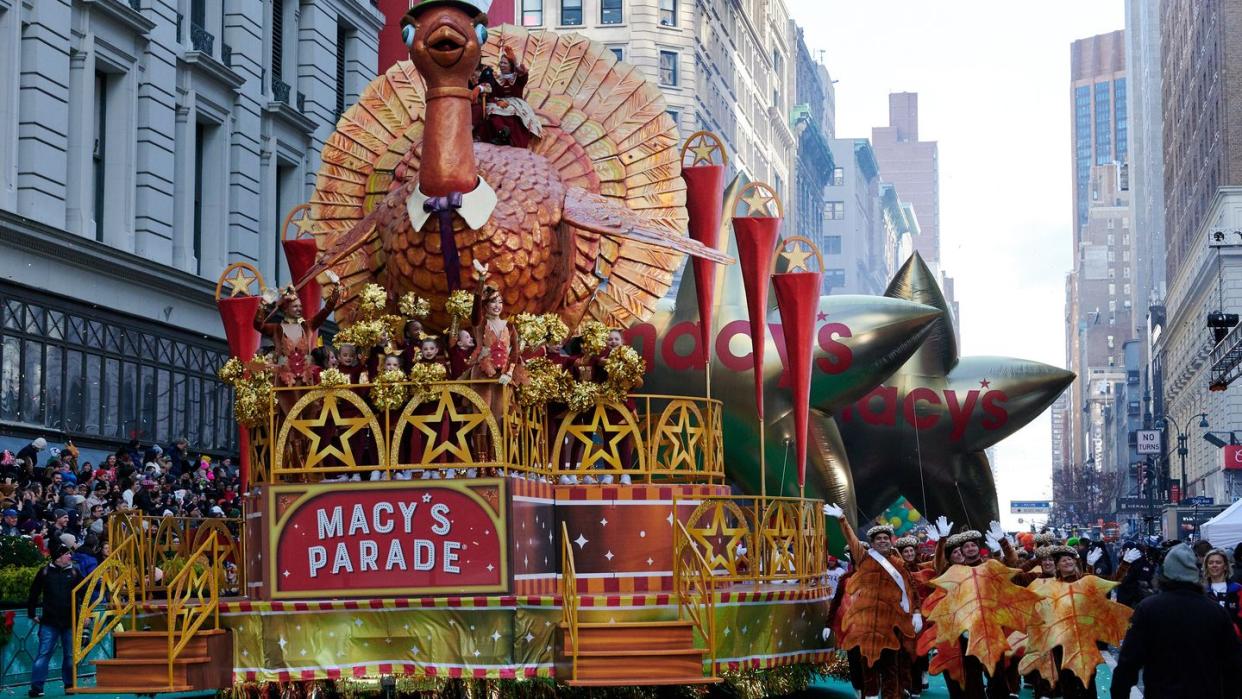 a person in a garment riding a bull in a parade