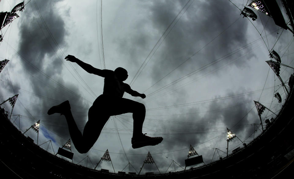 This picture taken with a fisheye lens shows France's Benjamin Compaore participating in the men's triple jump qualifying round during the athletics in the Olympic Stadium at the 2012 Summer Olympics, London, Tuesday, Aug. 7, 2012. (AP Photo/David J. Phillip)