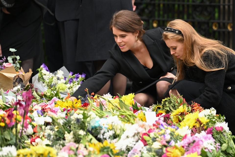 Las princesas Eugenie y Beatrice observan las flores que dejaron para la difunta reina Isabel II afuera del castillo Balmoral (WireImage)