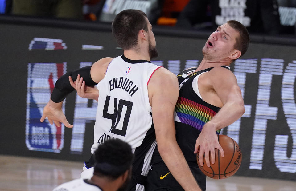 Los Angeles Clippers' Ivica Zubac, left, and Denver Nuggets' Nikola Jokic (15) tangle during the first half of an NBA conference semifinal playoff basketball game Monday, Sept. 7, 2020, in Lake Buena Vista, Fla. (AP Photo/Mark J. Terrill)