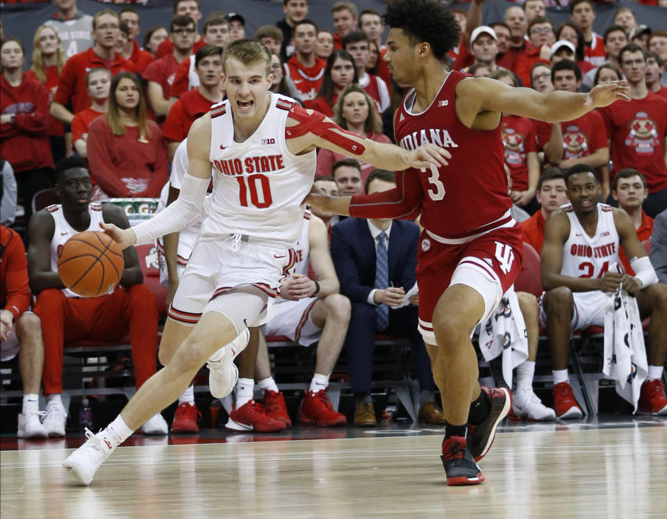 Ohio State's Justin Ahrens, left, dribbles past Indiana's Justin Smith during the second half of an NCAA college basketball game Saturday, Feb. 1, 2020, in Columbus, Ohio. Ohio State beat Indiana 68-59. (AP Photo/Jay LaPrete)