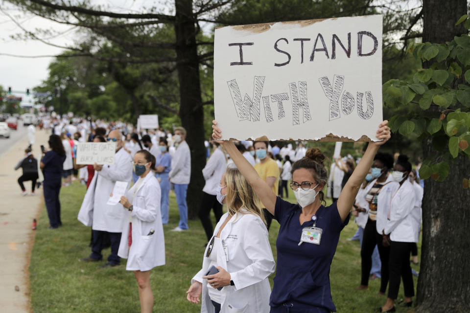 Healthcare professionals gather outside Barnes-Jewish Hospital to demonstrate in support of the Black Lives Matter movement Friday, June 5, 2020, in St. Louis, Mo. The White Coats for Black Lives protest was organized to stand in solidarity with those speaking out against the death of George Floyd who died after being restrained by Minneapolis police officers on May 25. (AP Photo/Jeff Roberson)