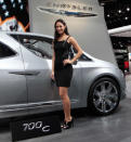 Model Tiffany Stone stands next to the Chrysler 700 C concept van as it is displayed on the final press preview day for the North American International Auto Show in Detroit, Michigan, January 10, 2012. REUTERS/Rebecca Cook