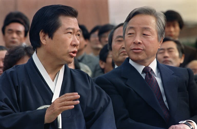 Then opposition presidential candidates Kim Dae-Jung (L) and Kim Young-Sam (R) chat during a rally held at the Korea University in Seoul on October 25, 1987