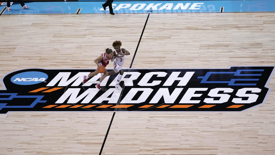 FILE - Ohio State guard Jacy Sheldon, left, drives past Texas guard Rori Harmon, right, during the first half of a college basketball game in the Sweet 16 round of the NCAA tournament at Spokane Arena on Friday, March 25, 2022, in Spokane, Wash. Twelve teams. Nine games. Four days. For a major college hoops fan who wants a centralized location to watch as much of the NCAA Tournament in person as possible, there might not be a better place than Spokane.(AP Photo/Ted S. Warren, File)