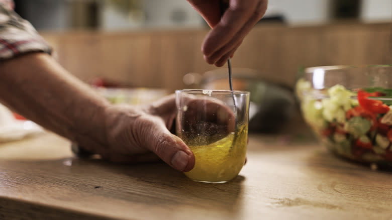 whisking homemade salad dressing 