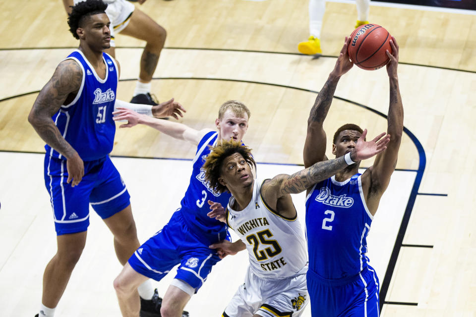 Drake's Tremell Murphy (2) grabs a rebound next to teammates Darnell Brodie (51) and Garrett Sturtz (3) and Wichita State's Clarence Jackson (25) during the first half of a First Four game in the NCAA men's college basketball tournament Thursday, March 18, 2021, at Mackey Arena in West Lafayette, Ind. (AP Photo/Robert Franklin)