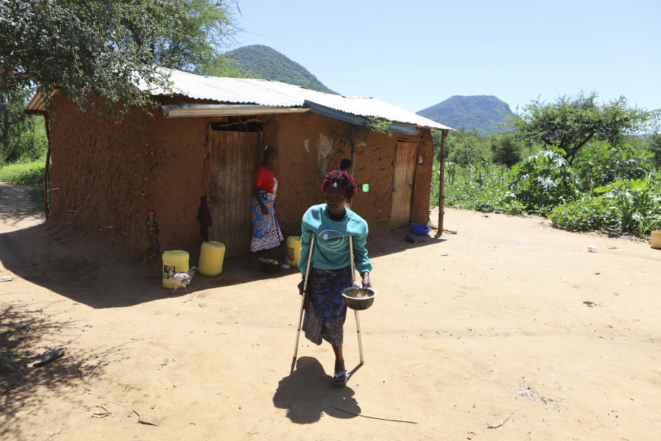 Esther Kangali, who lost her right leg to a snake bite, walks outside her home in Kitui, Kenya, Monday, May 13, 2024. Overall in Kenya, about 4,000 snakebite victims die every year while 7,000 others experience paralysis or other health complications, according to the local Institute of Primate Research. (AP Photo/Andrew Kasuku)