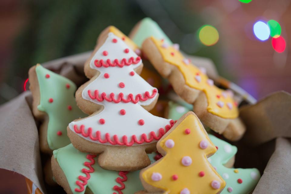 tin of iced sugar christmas tree cookies in green white and gold