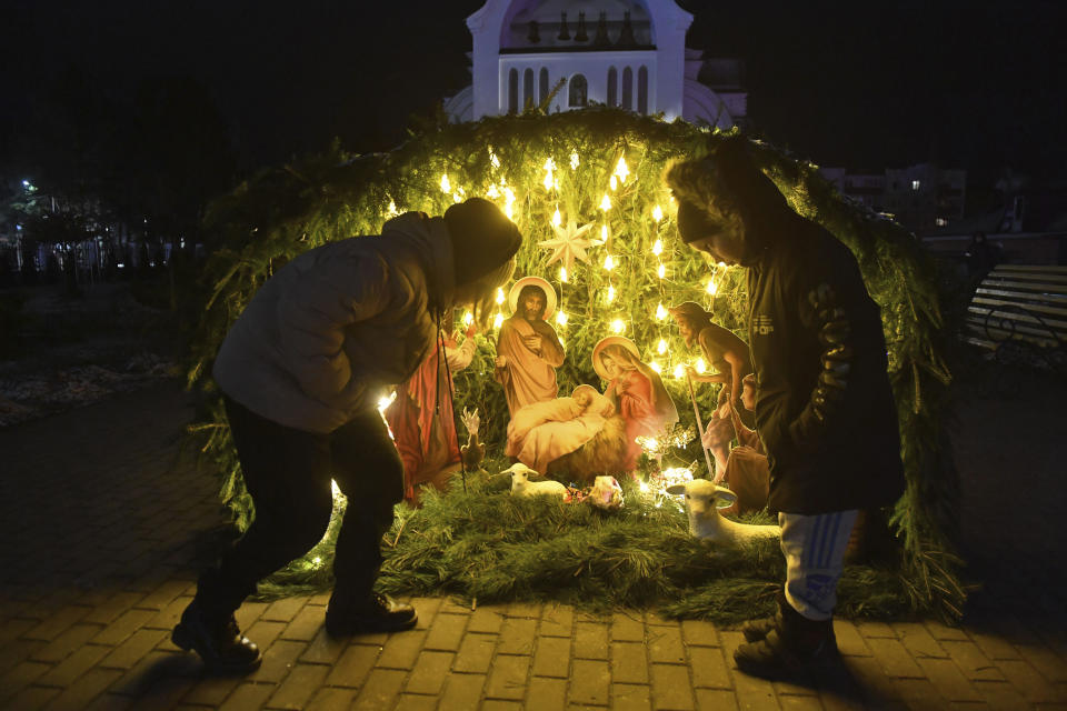 Children look at a Christmas crib near a church during Orthodox Christmas celebrations in Zhidkovichi, Gomel region, Belarus, Friday, Jan. 6, 2023. Orthodox Christians celebrate Christmas on Jan. 7, in accordance with the Julian calendar. (AP Photo)