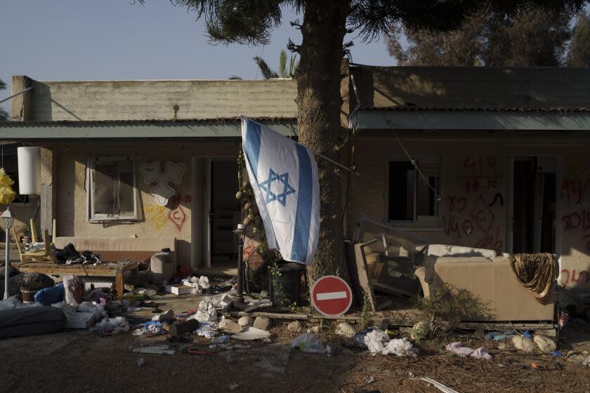 FILE - An Israeli flag hangs between destroyed houses in the kibbutz Kfar Azza, Israel, near the Gaza Strip, Monday, Nov. 13, 2023. It has become an Israeli mantra throughout the latest war in Gaza: Hamas is ISIS. Since the bloody Hamas attack on Oct. 7 that triggered the war, Israeli leaders and commanders have likened the Palestinian militant group to the Islamic State group. They point to Hamas' brutal slaughter of hundreds of civilians and compare their Gaza war to the U.S.-led campaign to defeat IS in Iraq and Syria. (AP Photo/Leo Correa, File)