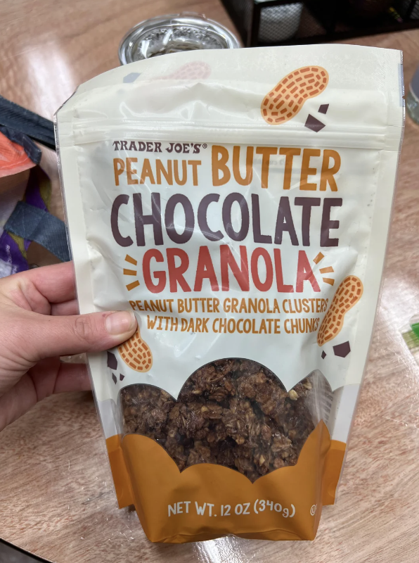 Package of Trader Joe's Peanut Butter Chocolate Granola Clusters with dark chocolate chunks, held in a hand