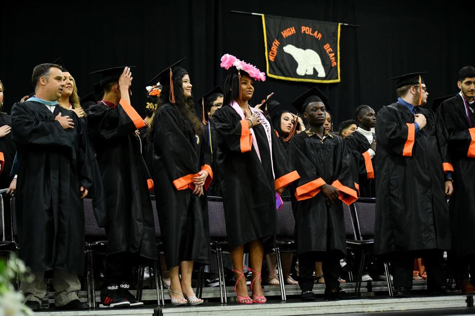 WORCESTER - Graduates stand for the Pledge of Allegiance during North High's war commencement at the DCU Center Wednesday, June 8, 2022.