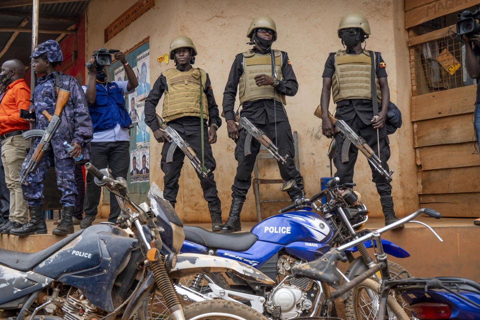 Security forces stand outside a polling station in Kampala, Uganda, Thursday, Jan. 14, 2021. Ugandans are voting in a presidential election tainted by widespread violence that some fear could escalate as security forces try to stop supporters of leading opposition challenger Bobi Wine from monitoring polling stations. (AP Photo/Jerome Delay)