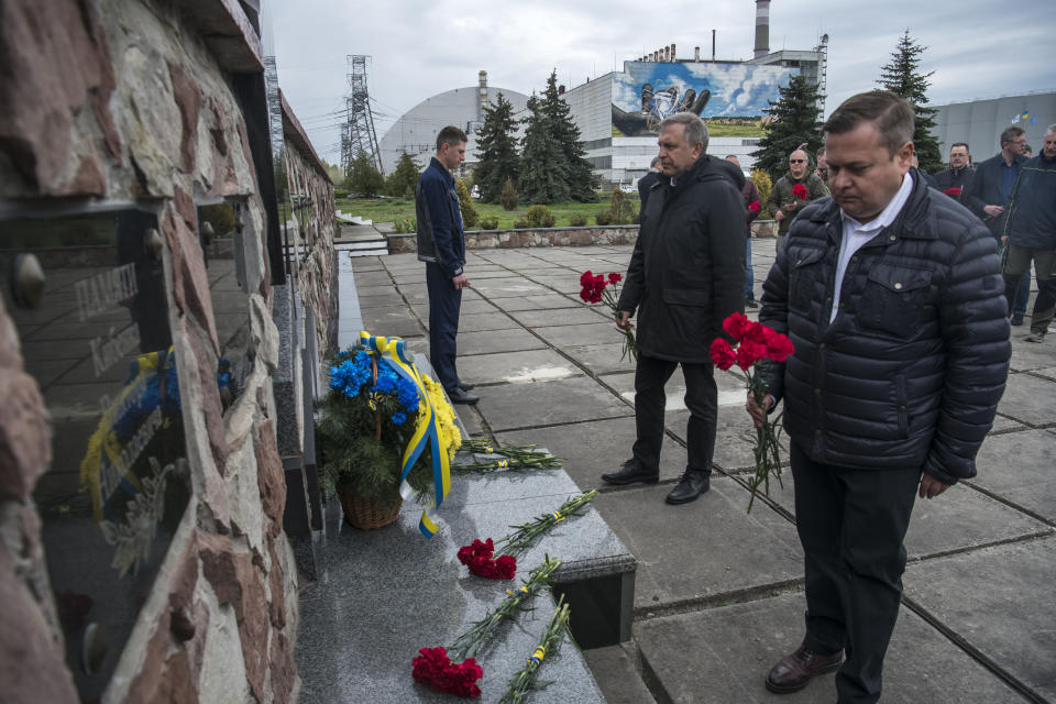 Chernobyl's nuclear power plant workers lay flowers at a monument to the victims of the Chernobyl tragedy during a memorial ceremony in Chernobyl, Ukraine, Wednesday, April 26, 2023. Ukrainian President Volodymyr Zelenskyy on Wednesday used the 37th anniversary of the world’s worst nuclear disaster to repeat his warnings about the potential threat of a new atomic catastrophe in Ukraine amid his country's war with Russia. (AP Photo/Wladyslaw Musiienko)