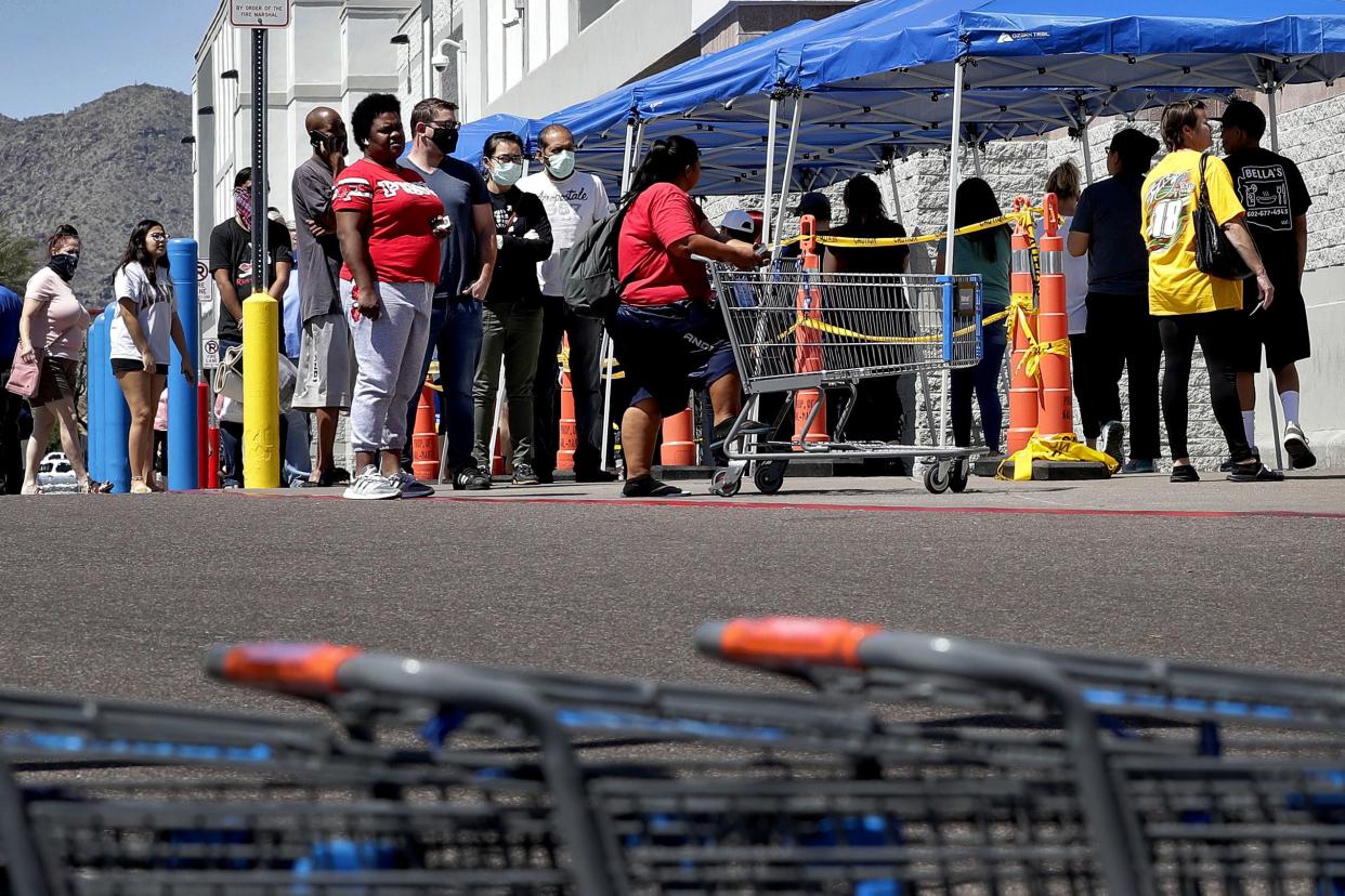 Some people wearing face masks wait in line to shop Saturday, April 4, 2020, in Tempe, Ariz. Honeywell announced that it is adding manufacturing capabilities in Phoenix to produce N95 face masks in support of the government's response to the novel coronavirus The company's Phoenix expansion will allow Honeywell to produce more than 20 million N95 disposable masks monthly to combat COVID-19.