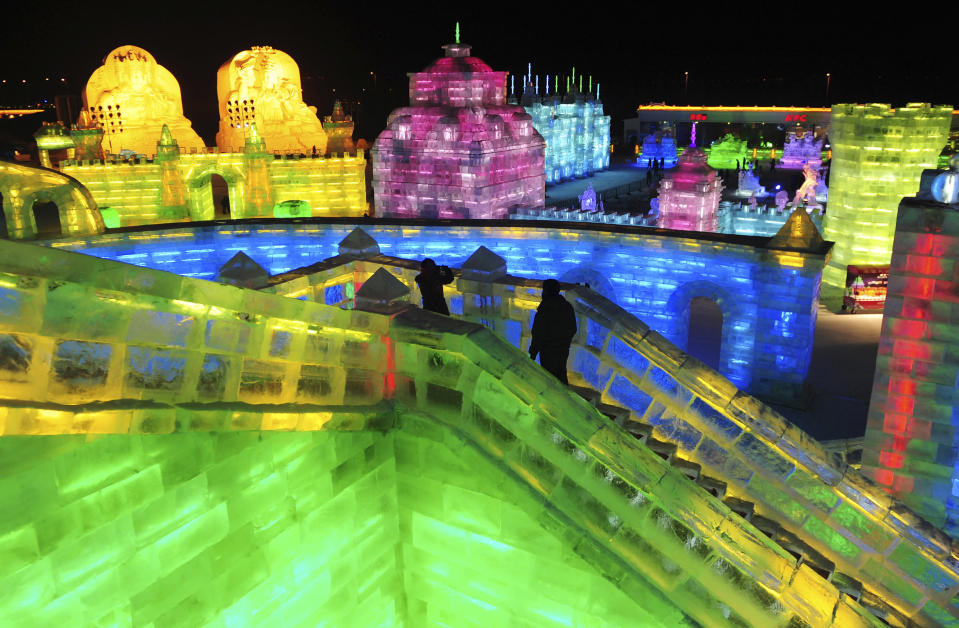 Tourists visit ice sculptures on the night before the opening ceremony of the 13th Harbin Ice and Snow World in Harbin, Heilongjiang province January 4, 2012. The Harbin International Ice and Snow Festival will be officially launched on January 5, 2012. Picture taken January 4, 2012. REUTERS/Sheng Li (CHINA - Tags: ENVIRONMENT SOCIETY TRAVEL)